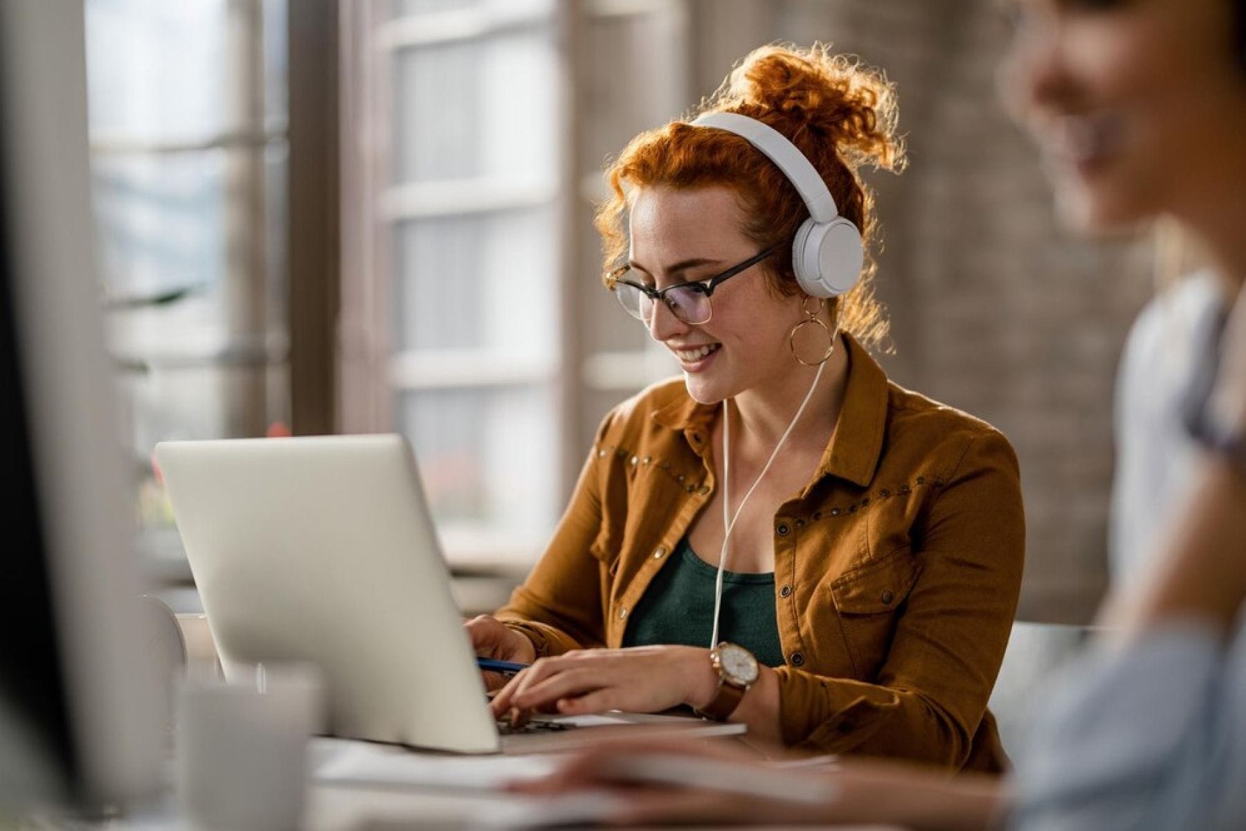 woman in the earphones working on a laptop