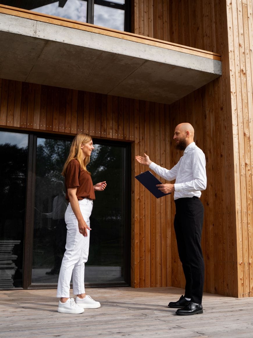 real estate broker and buyer talking in front of the house